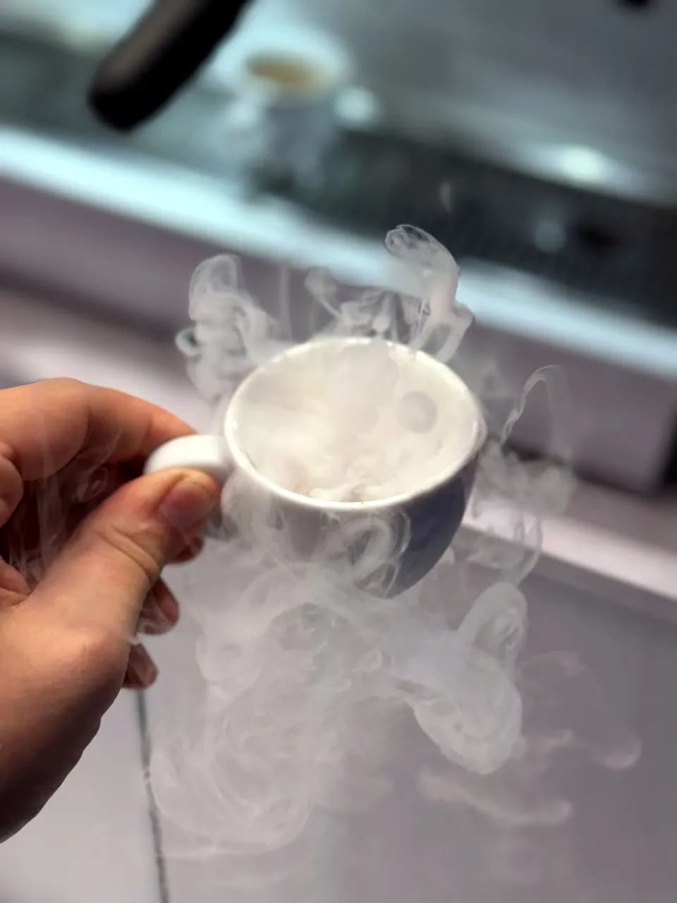 Nahaufnahme einer Espressotasse mit Crema und aufsteigendem Dampf